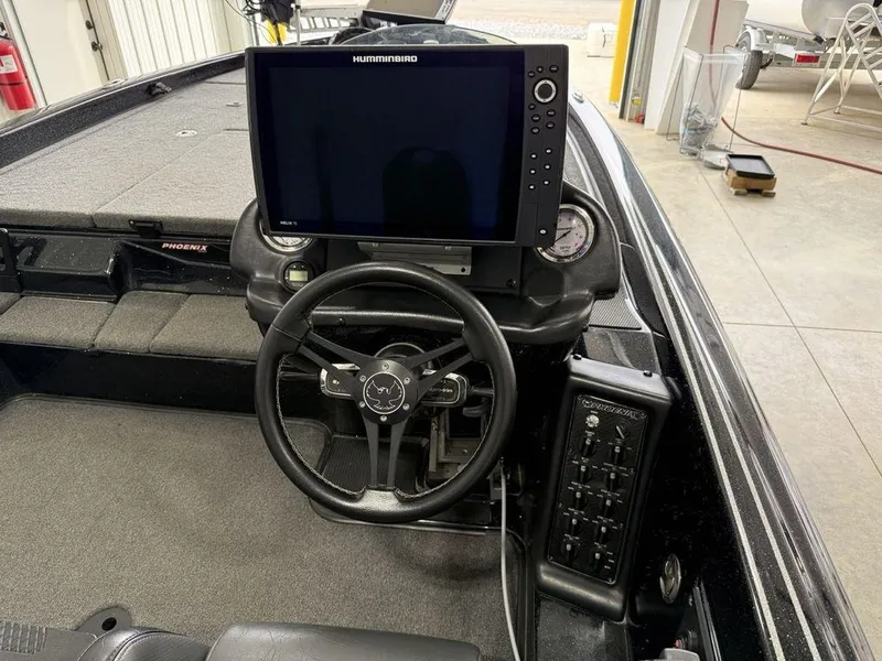 Slide: The Image of 2021 Phoenix 721 ProXP boat dashboard with steering wheel and Humminbird display. - 18