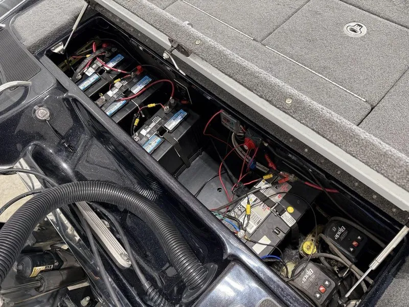 Slide: The Image of 2021 Phoenix 721 ProXP boat battery compartment with multiple batteries and wiring. - 25
