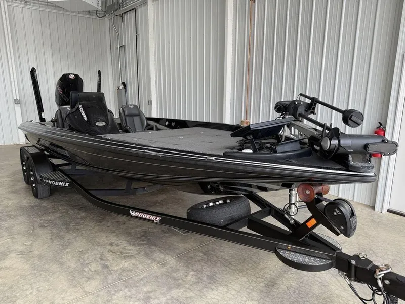 Slide: The Image of 2021 Phoenix 721 ProXP bass boat in a garage, sleek black design, on a trailer. - 3