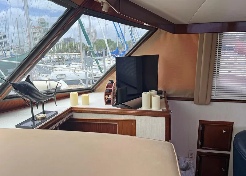 Slide: The Image of Interior of a 1976 Hatteras Convertible yacht with a TV and decorative candles. - 18