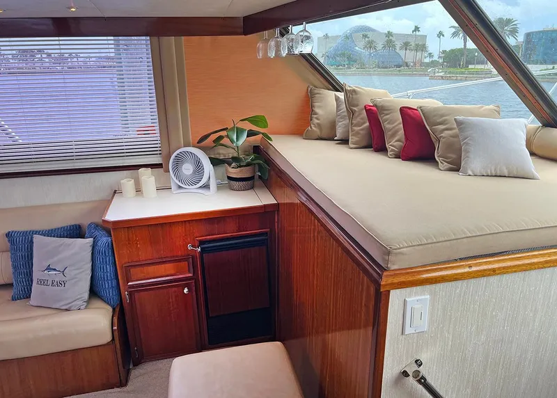 Slide: The Image of 1976 Hatteras Convertible yacht interior with cozy seating, cushions, and a small fan. - 19