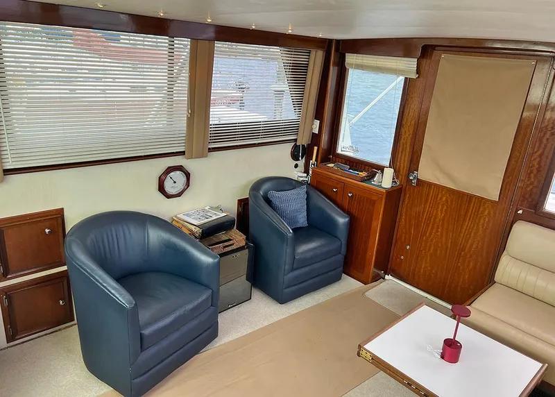 Slide: The Image of Interior of a 1976 Hatteras Convertible yacht with blue chairs and wooden accents. - 21