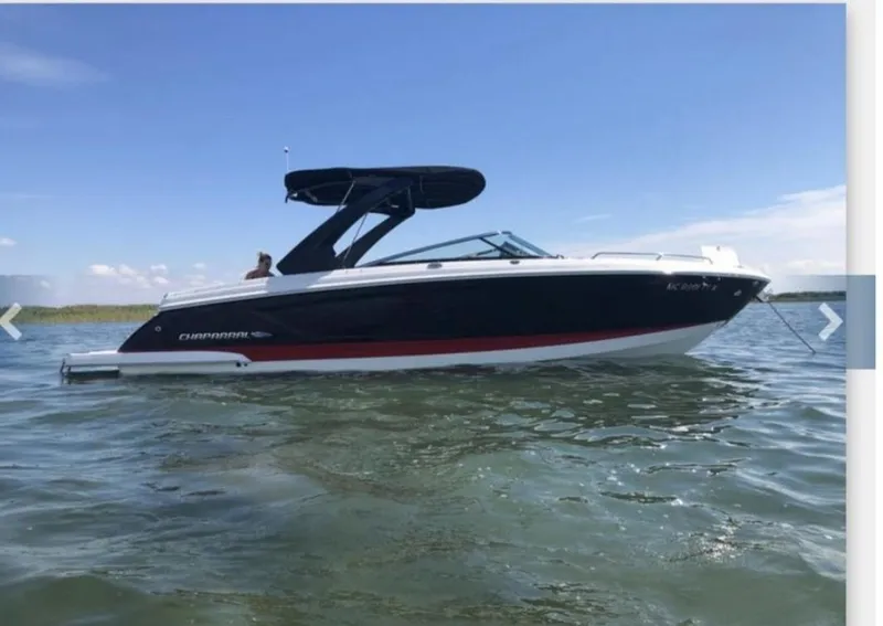 The Image of 2017 Chaparral 287 SSX boat on water, black hull, blue sky background. - 0