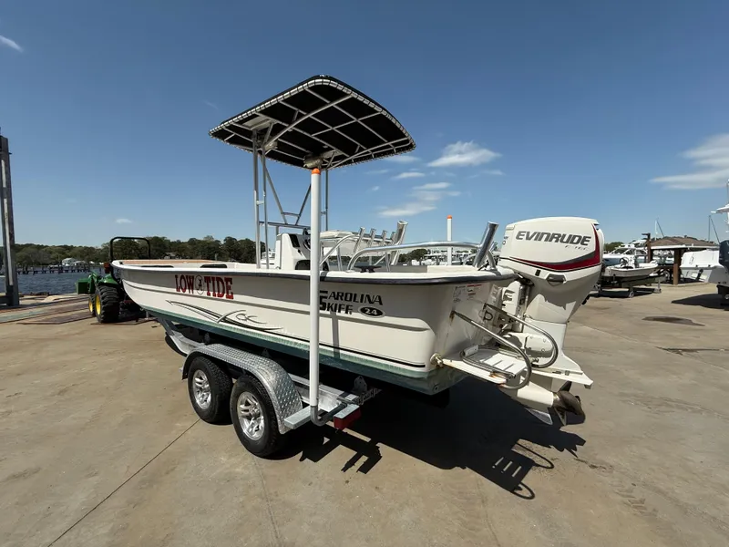 Slide: The Image of 2017 Carolina Skiff 24 DLX boat on trailer with Evinrude engine, dockside. - 2