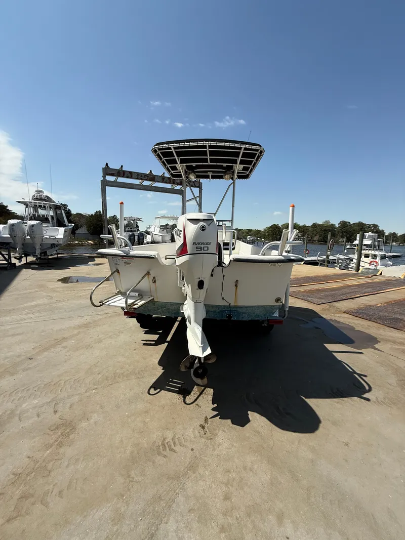 Slide: The Image of 2017 Carolina Skiff 24 DLX boat with outboard motor on a sunny dock. - 3