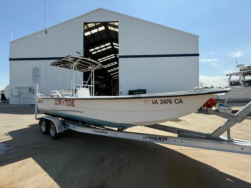 Slide: The Image of 2017 Carolina Skiff 24 DLX boat on trailer outside large warehouse. - 5