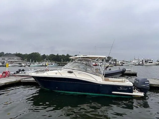 Slide: The Image of 2006 Scout 262 Abaco boat docked at a marina on a cloudy day. - 1