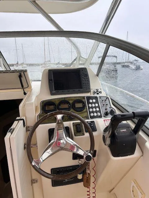 Slide: The Image of 2006 Scout 262 Abaco boat helm with steering wheel and navigation controls. - 10