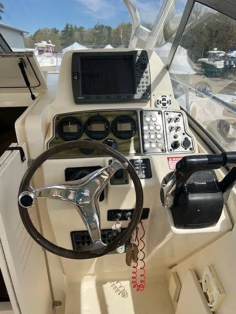 Slide: The Image of 2006 Scout 262 Abaco boat dashboard with steering wheel, navigation controls, and display screen. - 12