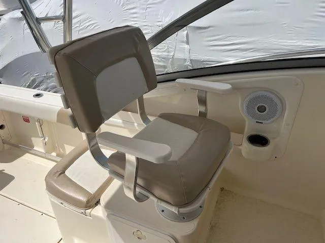 Slide: The Image of Captain's chair on 2006 Scout 262 Abaco boat, featuring beige upholstery and armrests. - 14