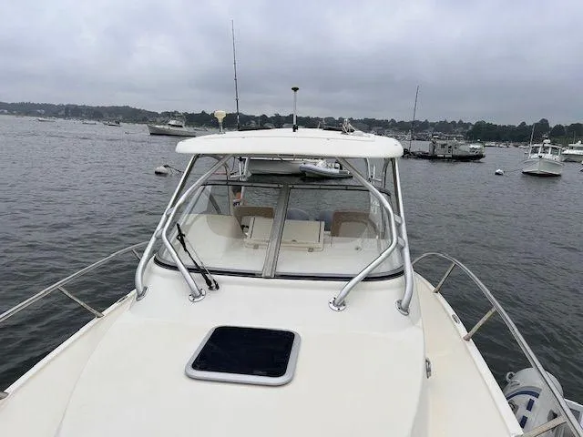 Slide: The Image of 2006 Scout 262 Abaco boat on calm water, overcast sky, marina in background. - 2