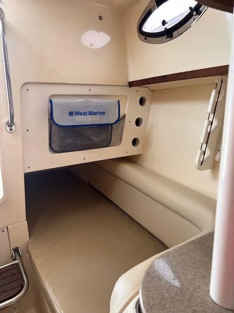 Slide: The Image of 2006 Scout 262 Abaco cabin interior with beige seating and storage compartment. - 24