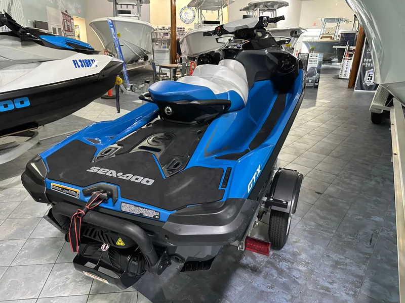 Slide: The Image of 2021 Sea-Doo GTX 170 jet ski in showroom, blue and black design, rear view. - 3