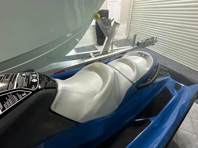 Slide: The Image of 2021 Sea-Doo GTX 170 jet ski with blue body and white seat in a garage. - 6