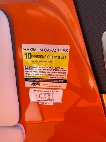 Slide: The Image of 2023 Crownline 220 SS LPX boat capacity label, orange background, maximum 10 persons or 1410 lbs. - 8