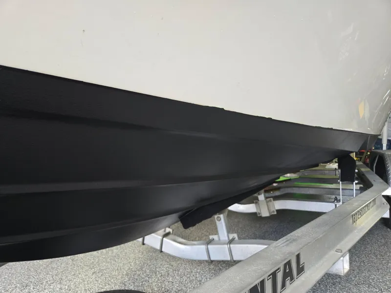 Slide: The Image of 2021 Sea Born LX22 Center Console boat on trailer, black hull detail. - 12