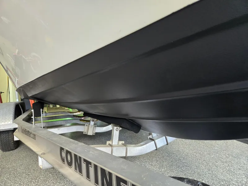 Slide: The Image of 2021 Sea Born LX22 Center Console boat on trailer, showcasing sleek black hull design. - 13