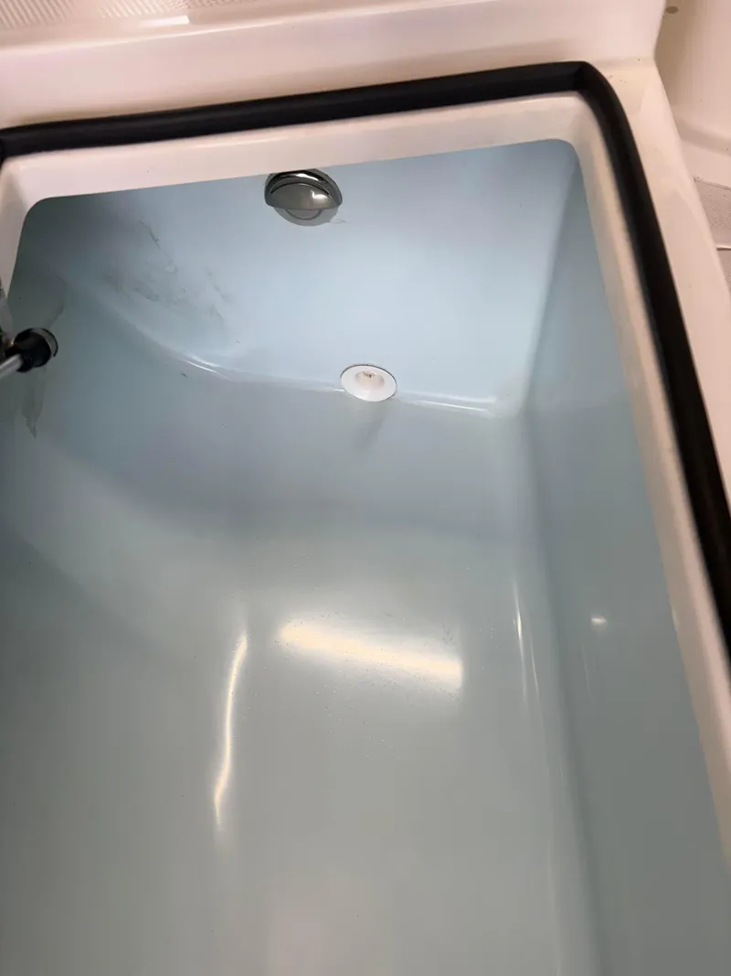 Slide: The Image of 2021 Sea Born LX22 Center Console livewell interior, clean and empty. - 17