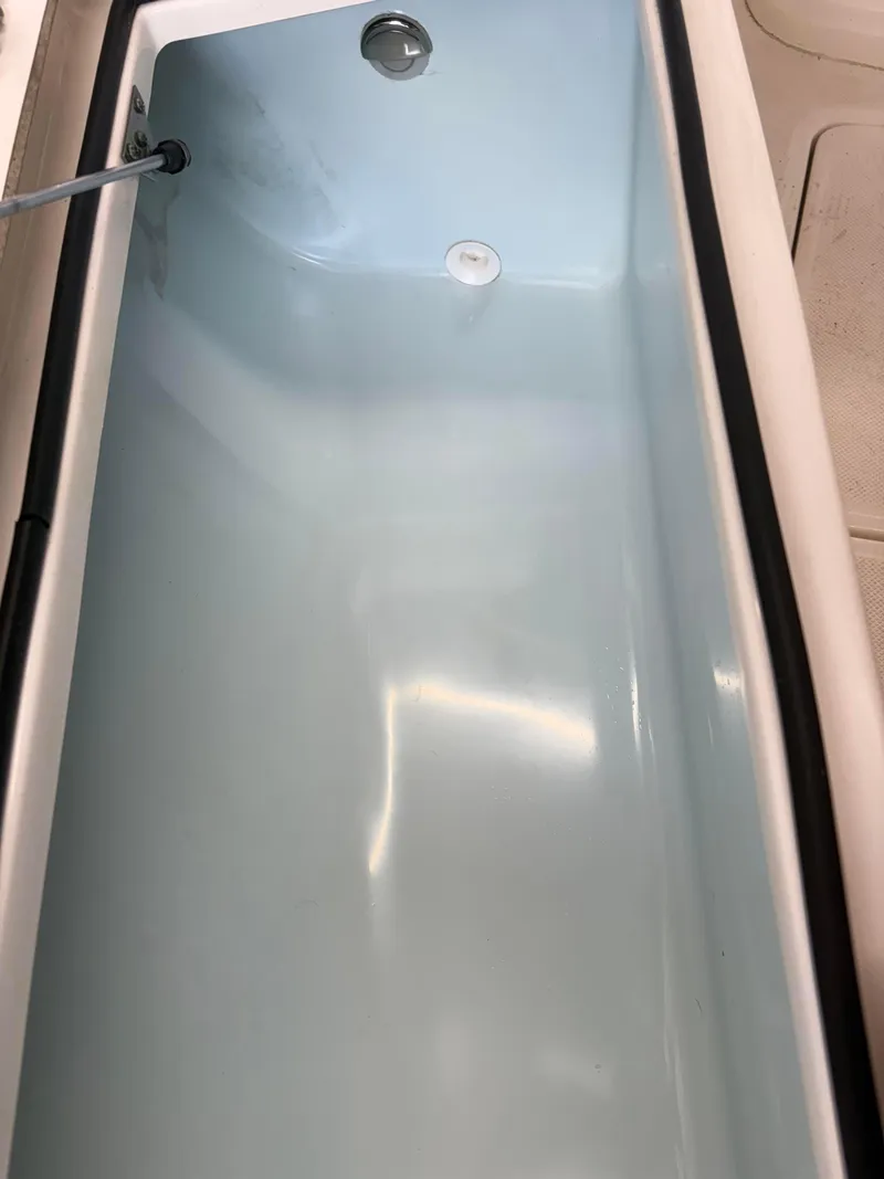 Slide: The Image of 2021 Sea Born LX22 Center Console livewell interior, clean and empty. - 18