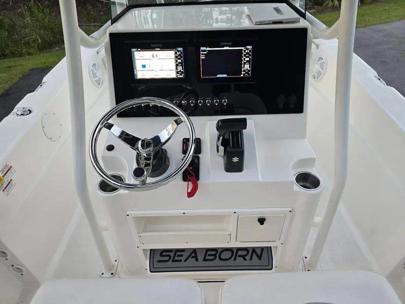 Slide: The Image of 2021 Sea Born LX22 Center Console boat dashboard with steering wheel and navigation screens. - 8