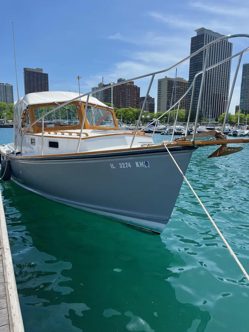 The Image of 1986 Dyer 29 Trunk Cabin boat docked in urban marina with city skyline. - 0