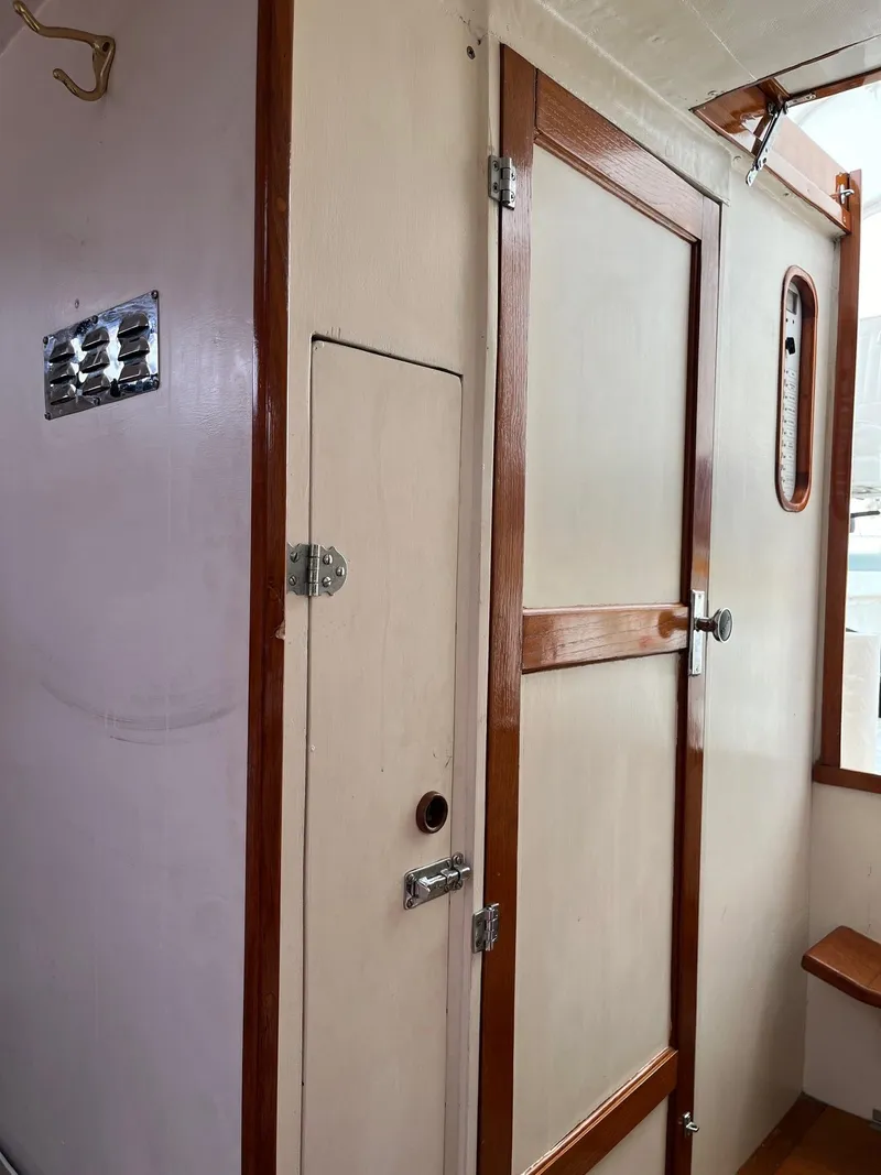 Slide: The Image of 1986 Dyer 29 Trunk Cabin interior with wooden door and paneling. - 13
