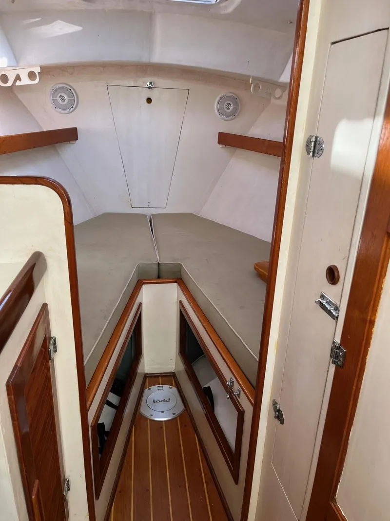 Slide: The Image of 1986 Dyer 29 Trunk Cabin interior with wood accents and cozy sleeping area. - 15