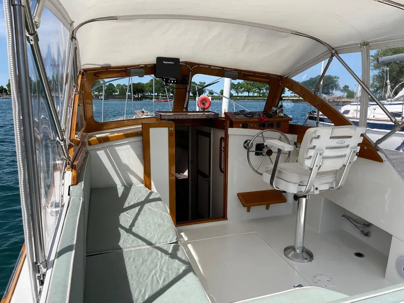 Slide: The Image of 1986 Dyer 29 Trunk Cabin boat interior with helm, seating, and wooden accents. - 22
