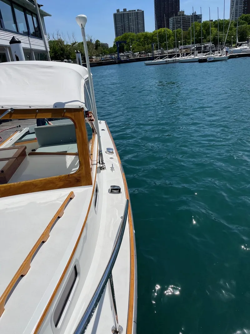 Slide: The Image of 1986 Dyer 29 Trunk Cabin boat docked in a marina with clear blue water. - 3
