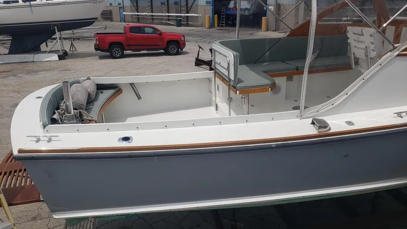 Slide: The Image of 1986 Dyer 29 Trunk Cabin boat in a marina with a red truck nearby. - 30