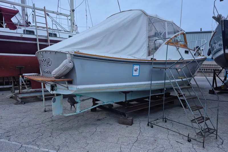Slide: The Image of 1986 Dyer 29 Trunk Cabin boat on dry dock with protective cover and ladder access. - 35
