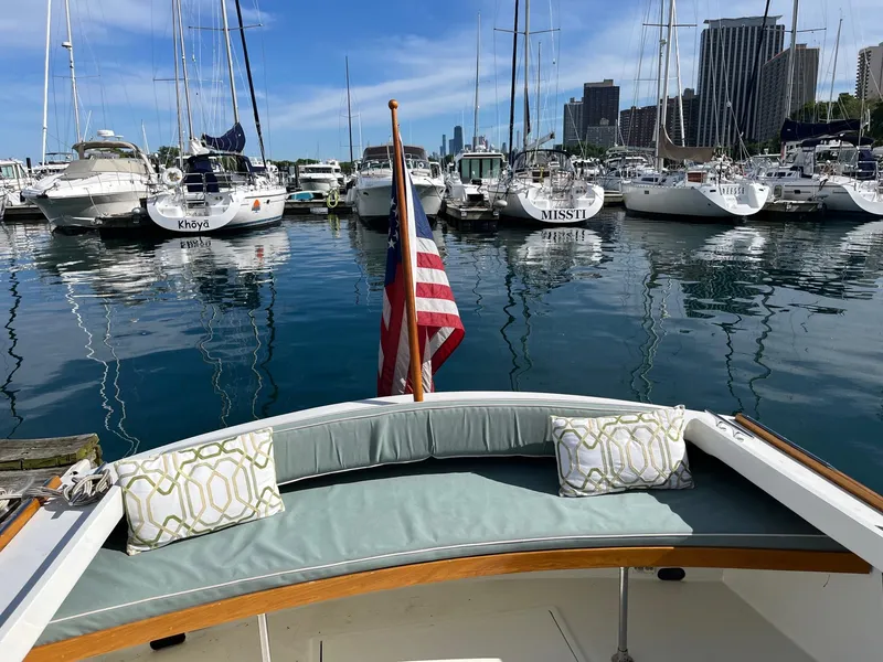 Slide: The Image of 1986 Dyer 29 Trunk Cabin boat docked in a marina with city skyline. - 7