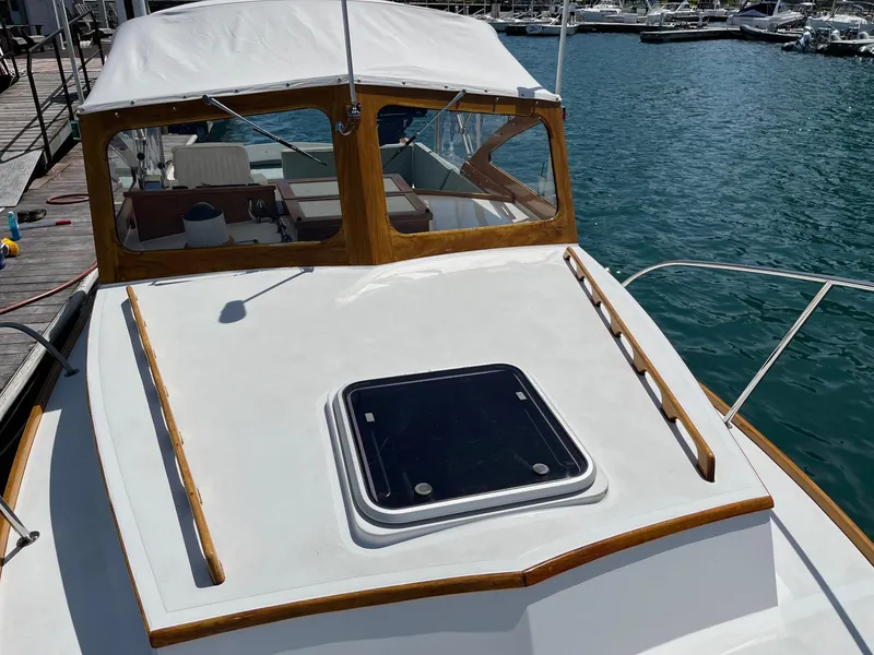 Slide: The Image of 1986 Dyer 29 Trunk Cabin boat with white deck and wooden trim, docked in marina. - 9