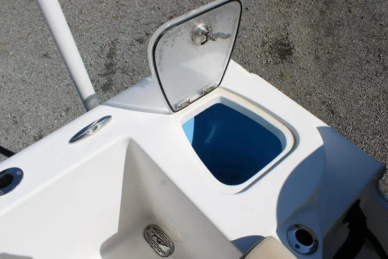 Slide: The Image of 2019 Tidewater 210 CC Adventure boat with open storage compartment and blue interior. - 10