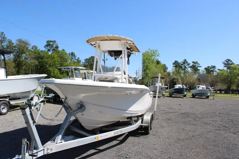 Slide: The Image of 2019 Tidewater 210 CC Adventure boat on trailer, parked outdoors under clear blue sky. - 26