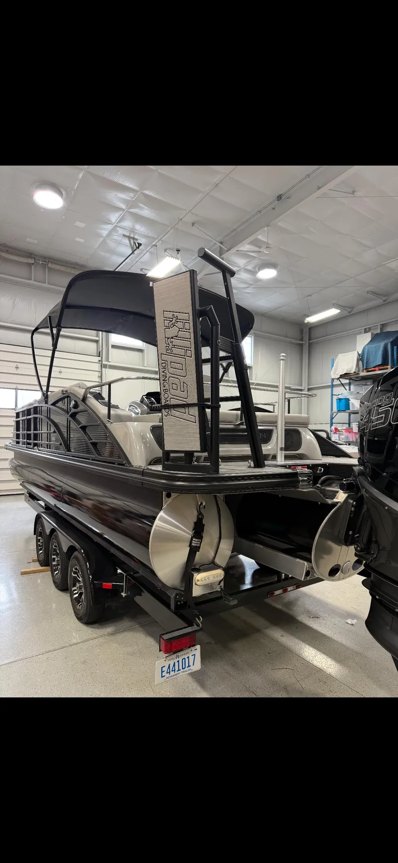 Slide: The Image of 2022 Bennington 25 QSBSG pontoon boat in a garage, rear view. - 3