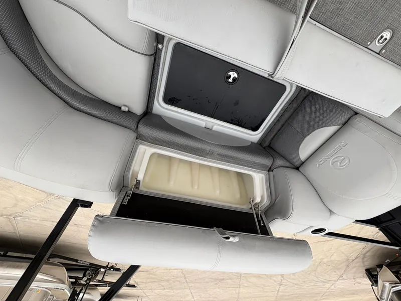 Slide: The Image of 2019 Regency 210 DL3 boat interior with open storage compartment and cushioned seating. - 13