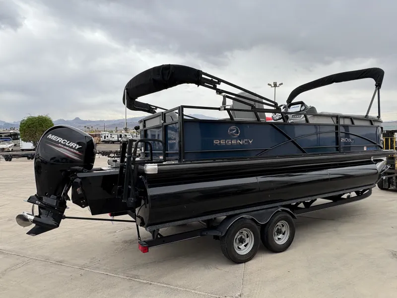 Slide: The Image of 2019 Regency 210 DL3 pontoon boat with Mercury outboard motor on trailer. - 2