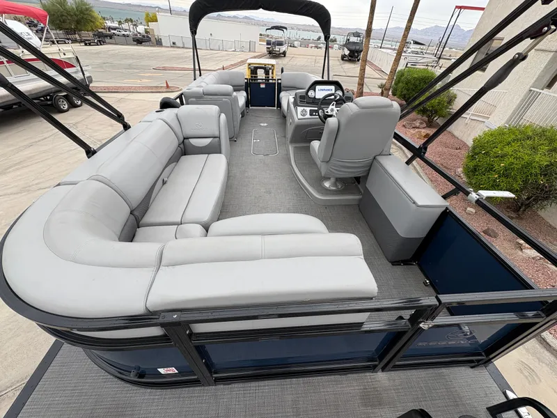 Slide: The Image of 2019 Regency 210 DL3 pontoon boat with spacious seating and modern helm, docked at marina. - 9