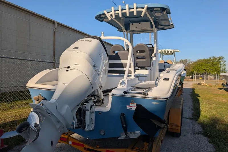Slide: The Image of 2025 Sea Pro 245 FLX boat with powerful outboard motor, parked outdoors. - 2