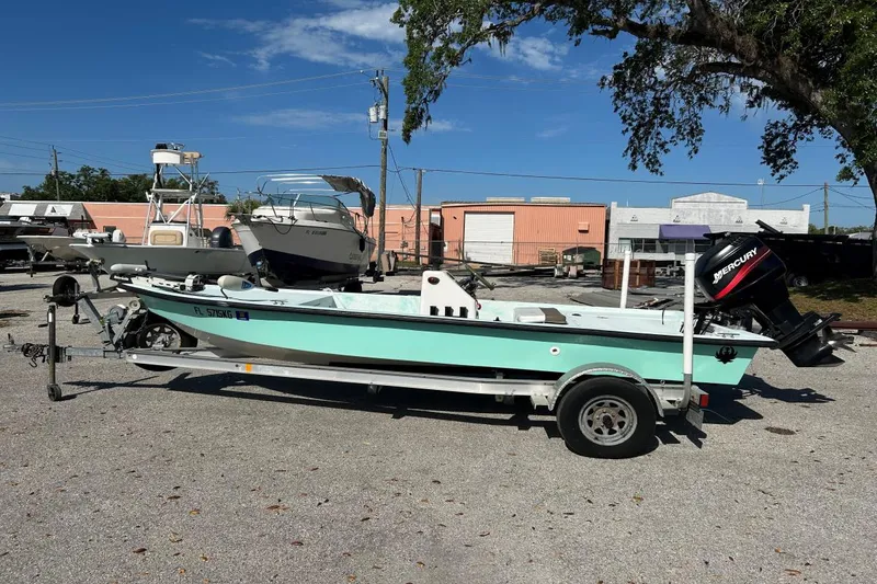 Slide: The Image of 1999 BAYCRAFT 18 SKIFF boat on trailer with Mercury outboard motor, parked outdoors. - 11