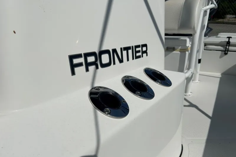 Slide: The Image of 2020 Frontier 2104 CC boat interior with rod holders and logo. - 19