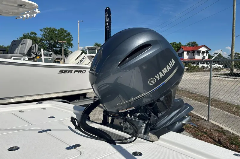 Slide: The Image of Yamaha outboard motor on a 2020 Frontier 2104 CC boat, parked near a Sea Pro. - 5