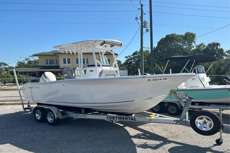 Slide: The Image of 2021 Sea Pro 219 Deep-V boat on trailer, parked outdoors under clear sky. - 1