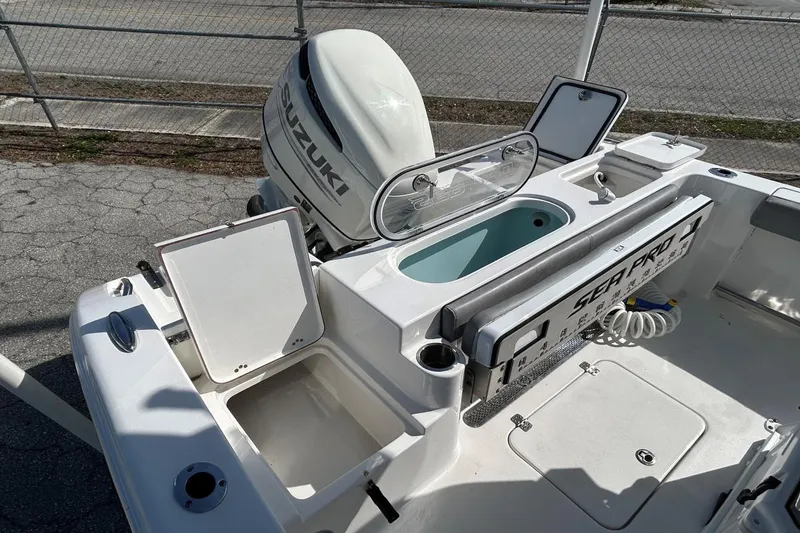 Slide: The Image of 2021 Sea Pro 219 Deep-V boat with Suzuki outboard motor, featuring storage compartments and livewell. - 10