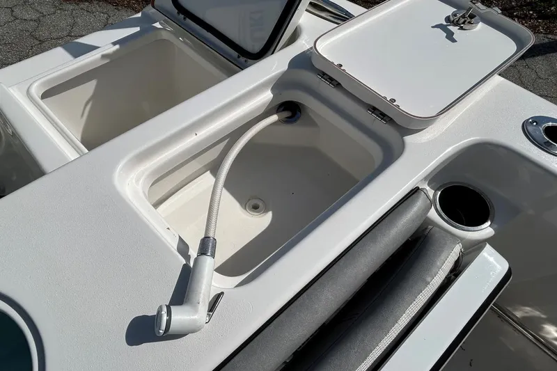 Slide: The Image of 2021 Sea Pro 219 Deep-V boat with open storage compartments and hose attachment. - 11