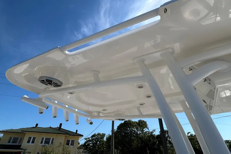 Slide: The Image of 2021 Sea Pro 219 Deep-V boat T-top with rod holders and speaker, under clear blue sky. - 21