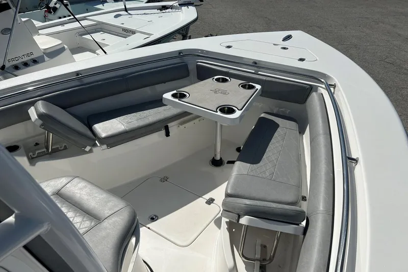 Slide: The Image of 2021 Sea Pro 219 Deep-V boat interior with seating and table, featuring cup holders. - 9