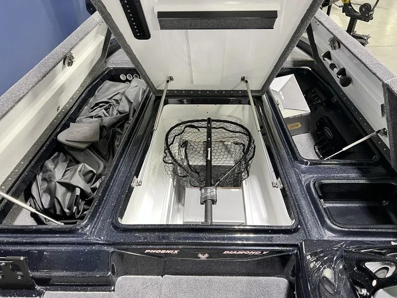 Slide: The Image of 2025 Phoenix 920 Elite boat storage compartments with fishing net and gear. - 12