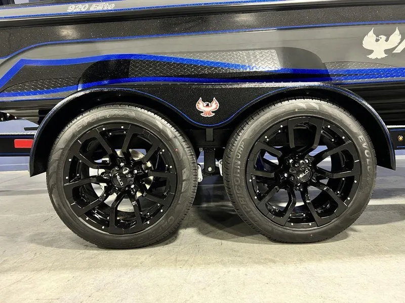 Slide: The Image of Black wheels of a 2025 Phoenix 920 Elite boat trailer with blue accents. - 3